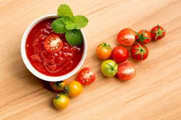 Tomato on sauce with peppermint  in a bowl on wood table at kitchen of restaurant.Ready to serve.