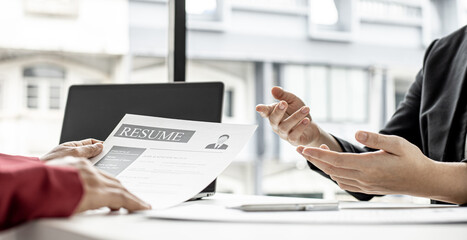 The job applicant is attending a job interview with the department manager and is introducing himself and explaining the information in the resume to the manager in order to be elected to the company.