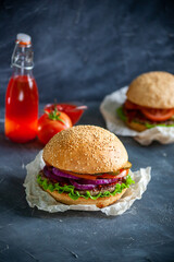 Hamburger lies on the board on a dark background