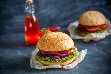 Hamburger lies on the board on a dark background