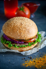 Hamburger lies on the board on a dark background