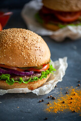 Hamburger lies on the board on a dark background