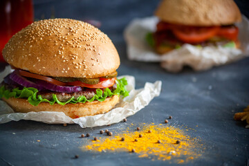 Hamburger lies on the board on a dark background