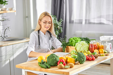 Young nutritionist young doctor writing diet plan on table. Right nutrition and slimming concept