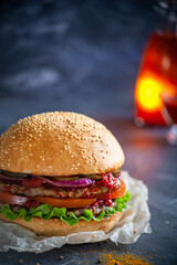 Hamburger lies on the board on a dark background