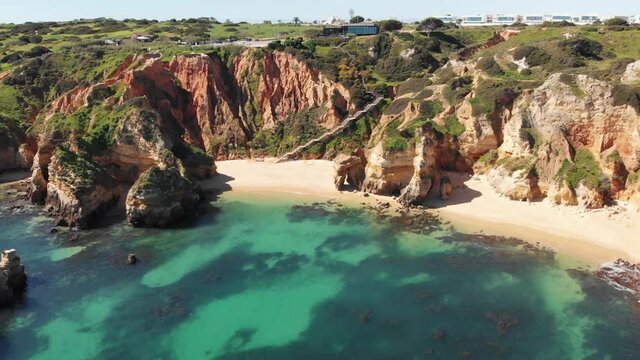 Pristine Camilo Beach in Lagos Idyllic coastline in Algarve, Portugal - Aerial establishing shot
