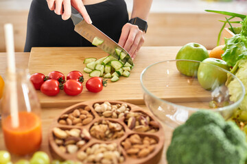 Close-up photo of female hands with knife cutting fresh vegetables