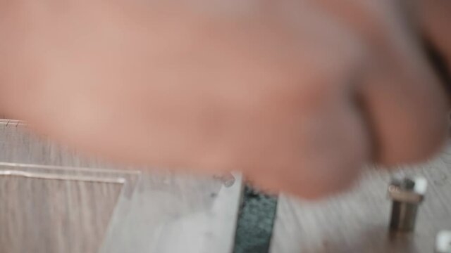 Close up of leather craftsman who is staming letters on leather bracelet. Handmade accessories.