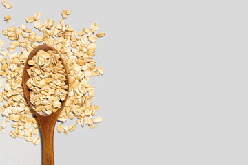 wooden spoon and oatmeal on gray background