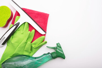 gloves, cleaning products, rag and window cleaning brush lie on a white background