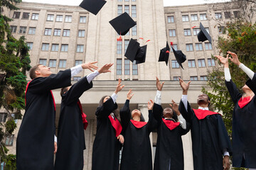 International group of students throwing graduation caps up