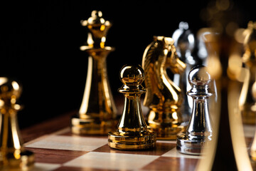 Gold and silver chess figures placed on chessboard