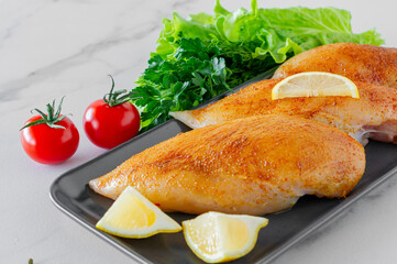 Raw chicken breasts with greens and tomatoes ready for cooking. dietary food