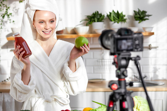 Portrait of young european female holding fresh green apple and juice in hand, recommending healthy eating and lifestyle