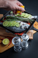 Fresh sea fish with olive oil, spices and lemon ready for cooking. Dorado or sea bream fish. 