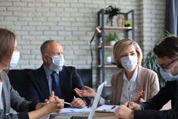 Business team in protective masks works in the office.
