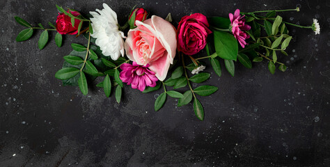 Fototapeta na wymiar Banner for website with composition of delicate summer flowers on a black background top view, free space for text. Bouquet of pink roses and white daisies
