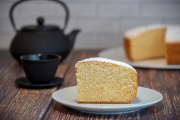 A piece of sponge cake is served with a cup of tea..