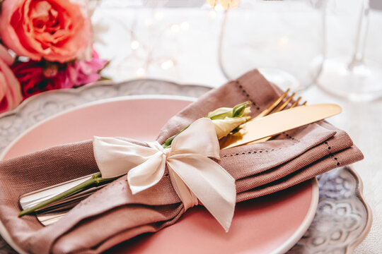  Wedding table setting concept. Plate, cutlery on linen napkin and flowers, close up, toned photo soft focus