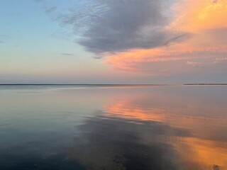 sunset over the bay with cloud reflections onto water 