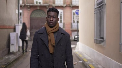 Moody pensive black african man walking in city