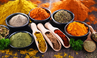 Variety of spices on wooden kitchen table.