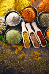 Variety of spices on wooden kitchen table.