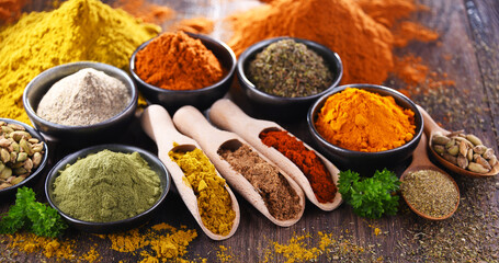 Variety of spices on wooden kitchen table.