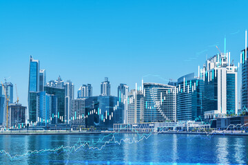 Obraz premium Skyscrapers of Dubai business downtown. International hub of trading and financial services of Western Asia. FOREX graph and chart concept. Double exposure. Dubai Canal waterfront.