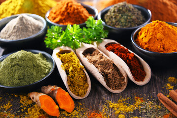 Variety of spices on wooden kitchen table.