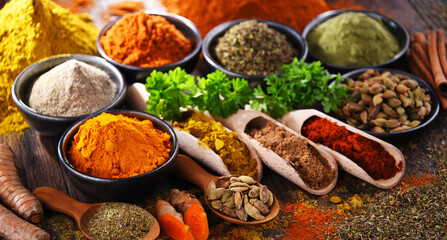 Variety of spices on wooden kitchen table.