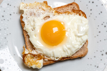 Toast sandwich with fried egg on a plate. Light, quick snack.