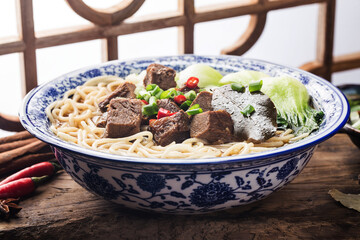 Spicy red soup beef noodle in a bowl on wooden table