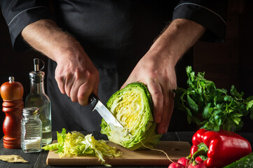 Chef hands slicing cabbage with a knife. Cooking vegetable salad in the restaurant kitchen