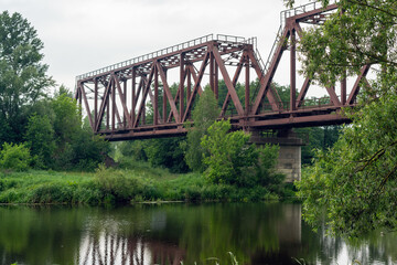 Old rusty railway bridge over the river