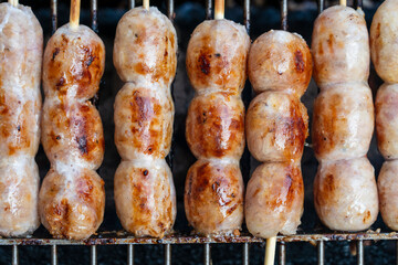 Grilled Thai sausage at street food market in Thailand, closeup. Traditional Thai sausage with pork and rice, delicious street food
