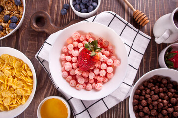 bowls with strawberry, chocolate sweet corn balls, muesli and corn flakes with berries. Delicious and healthy breakfast cereal. Top view.