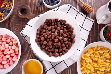 bowls with strawberry, chocolate sweet corn balls, muesli and corn flakes with berries. Delicious and healthy breakfast cereal. Top view.