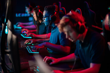 A multi-racial team of esports athletes conducts a training session before an online shooter...