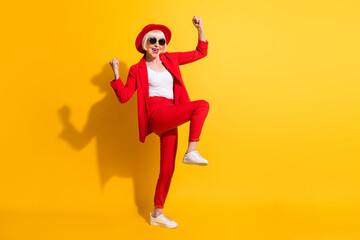 Full length body size photo of elder woman in red suit sunglass gesturing like winner isolated on...