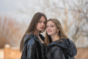 Fototapeta premium Portrait of two charming young girls, outdoors, close up
