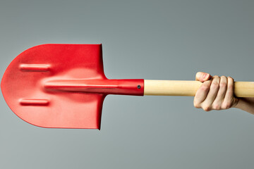 Big Red shovel with wooden handle isolated on gray