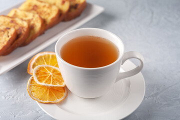 A cup of tea with dried orange and French toast. The concept of a healthy breakfast.