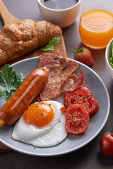 Delicious breakfast with fresh croissants, fried eggs with bacon and coffee served, orange juice. strawberry, butterhead, blackberry salad. full american breakfast top view.