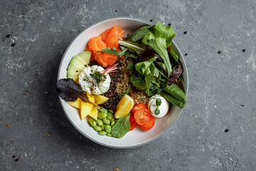 fresh healthy light breakfast, business lunch. Breakfast with poached egg, buckwheat, red fish, fresh salad, cucumbers, business lunch concept
