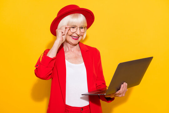 Photo Portrait Of Senior Business Woman Working On Computer Wearing Glasses Red Formal Wear Isolated Bright Yellow Color Background