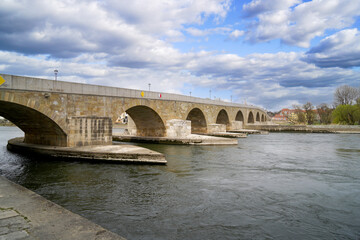 Fototapeta na wymiar Stone bridge in Regensburg over the Danube with cathedral and Bruck Mandl