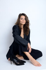 Young Polish woman in studio. Slim woman with dark hairs wearing black jacket and high heels.