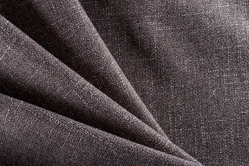 dense upholstery fabric of dark brown color with a linen texture, drapery folds