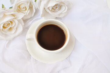 cup of coffee with white roses in the morning
